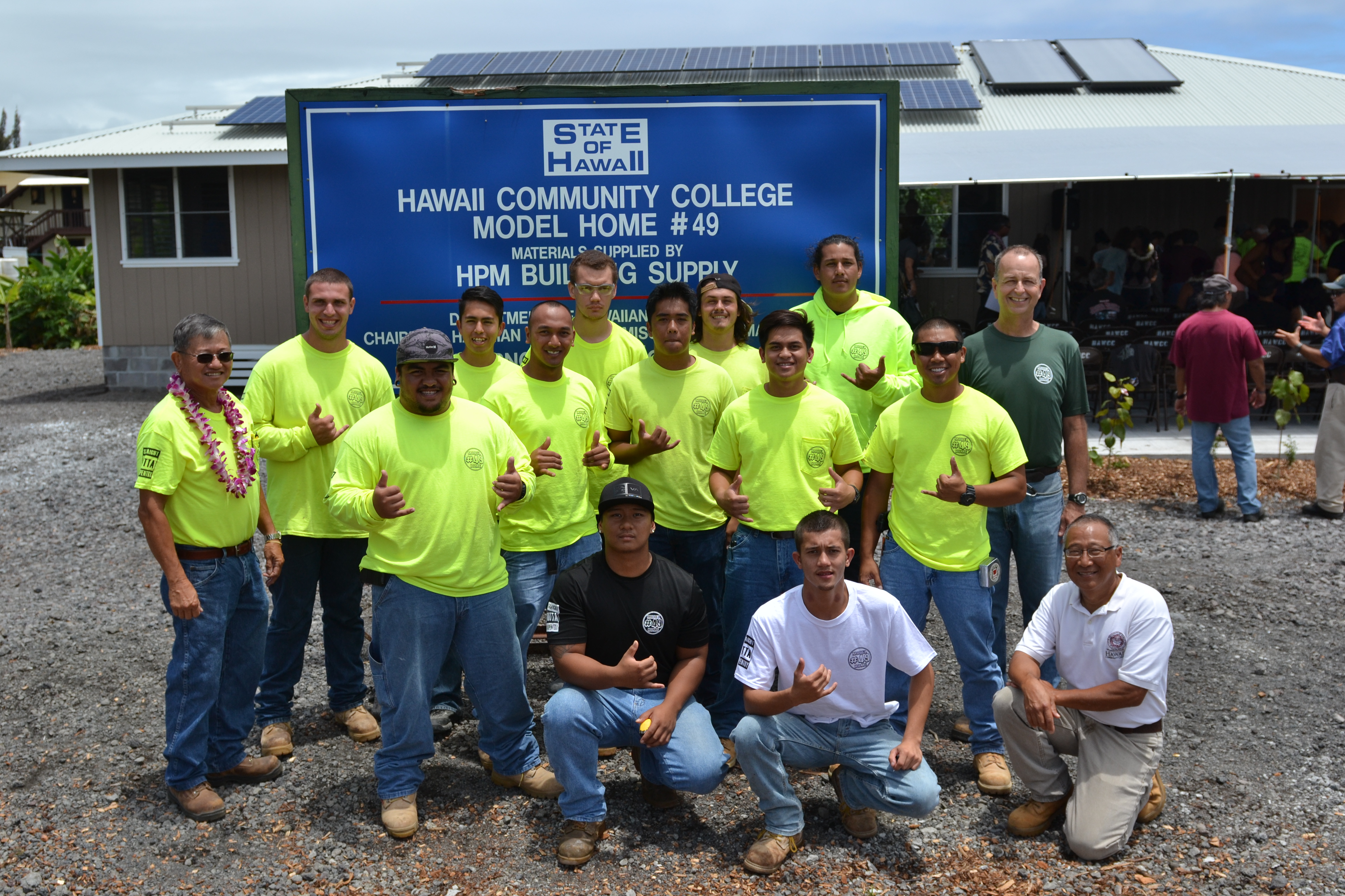 Students pose in front of house at dedication ceremony 
