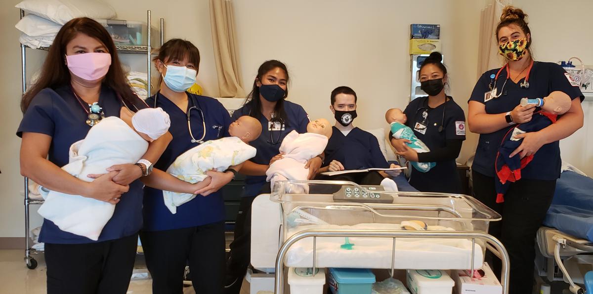 students in lab holding infant models